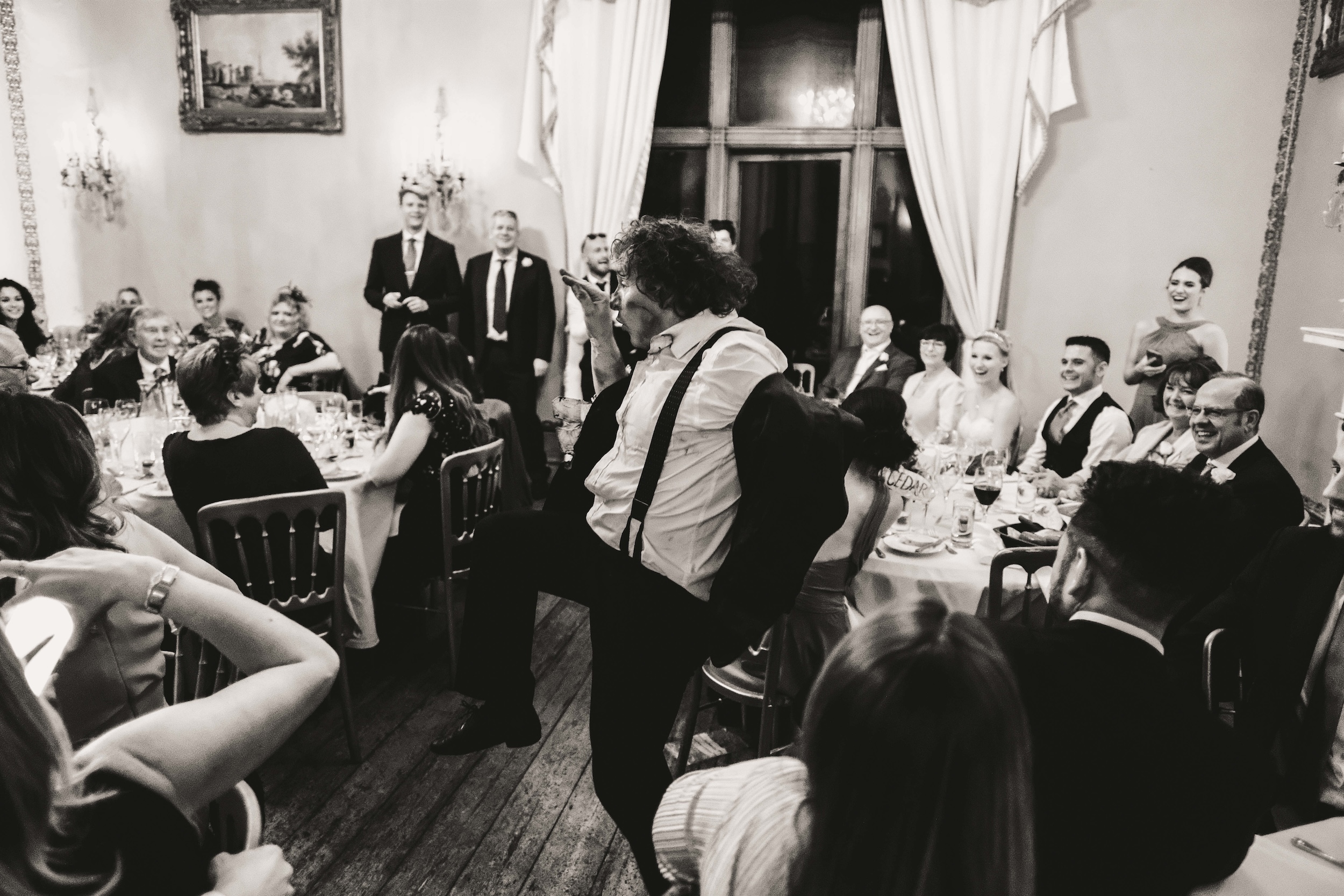 Wedding guests dancing together in a black and white photograph
