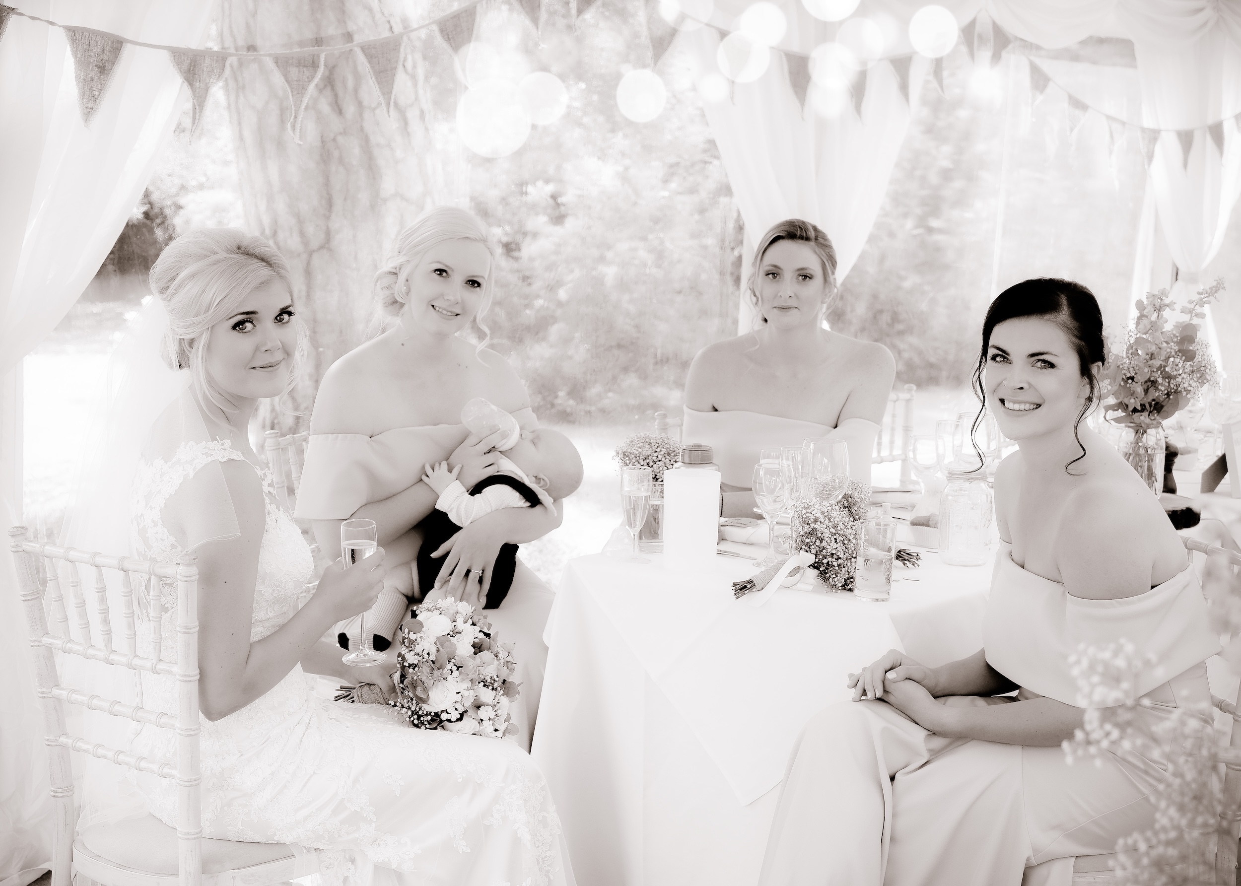 Bride and bridesmaids sharing a moment around a table