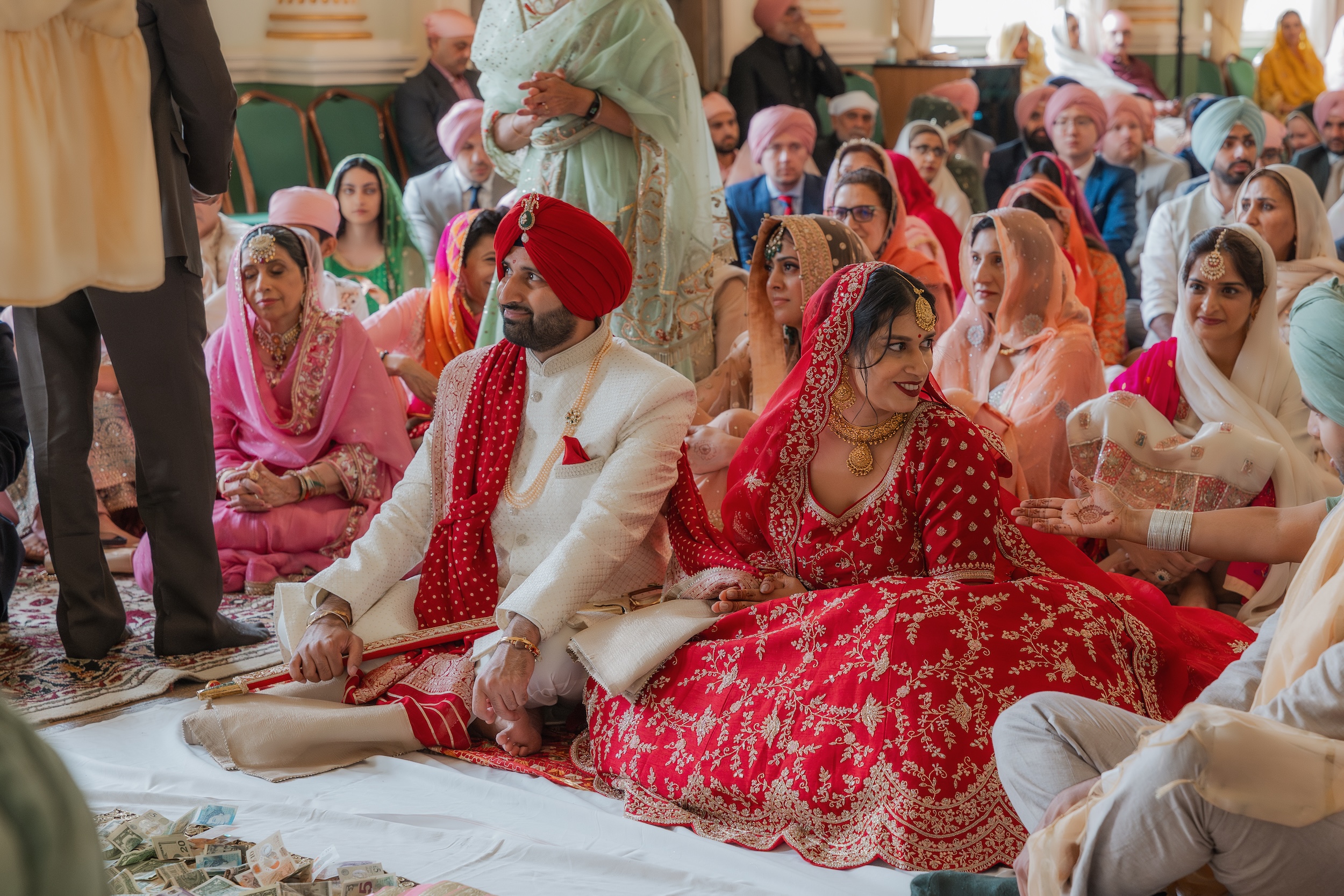 Couple seated together during their wedding ceremony, surrounded by guests