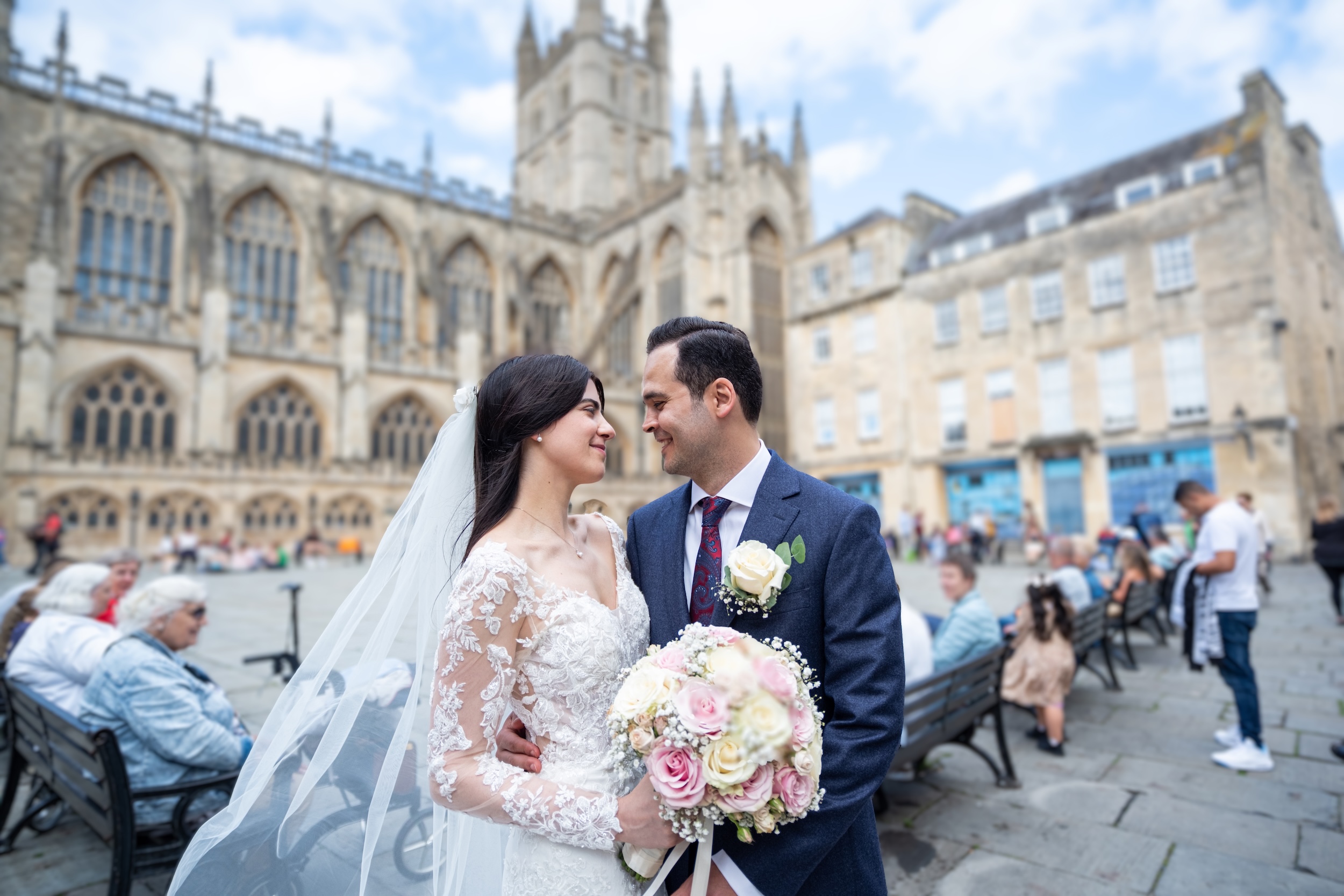 Newlyweds sharing a kiss in front of Bath Abbey