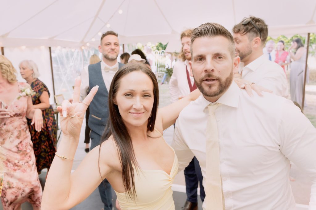 Family and friends enjoying Alice and Ben’s wedding celebration inside the marquee at Seymours Court.