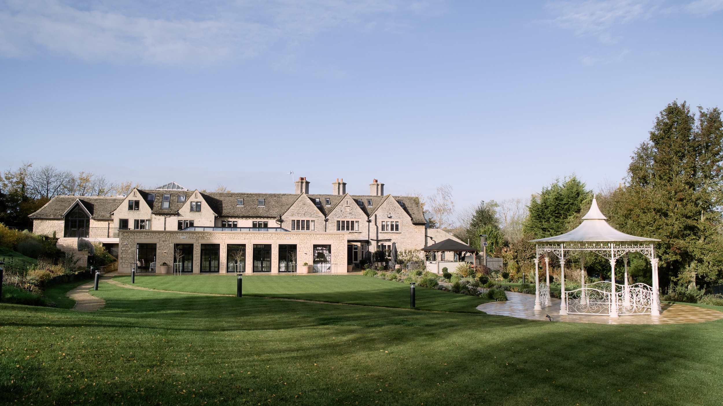 The Pear Tree’s stone house and reception rooms overlooking the lawn, with the white garden pavilion to one side.