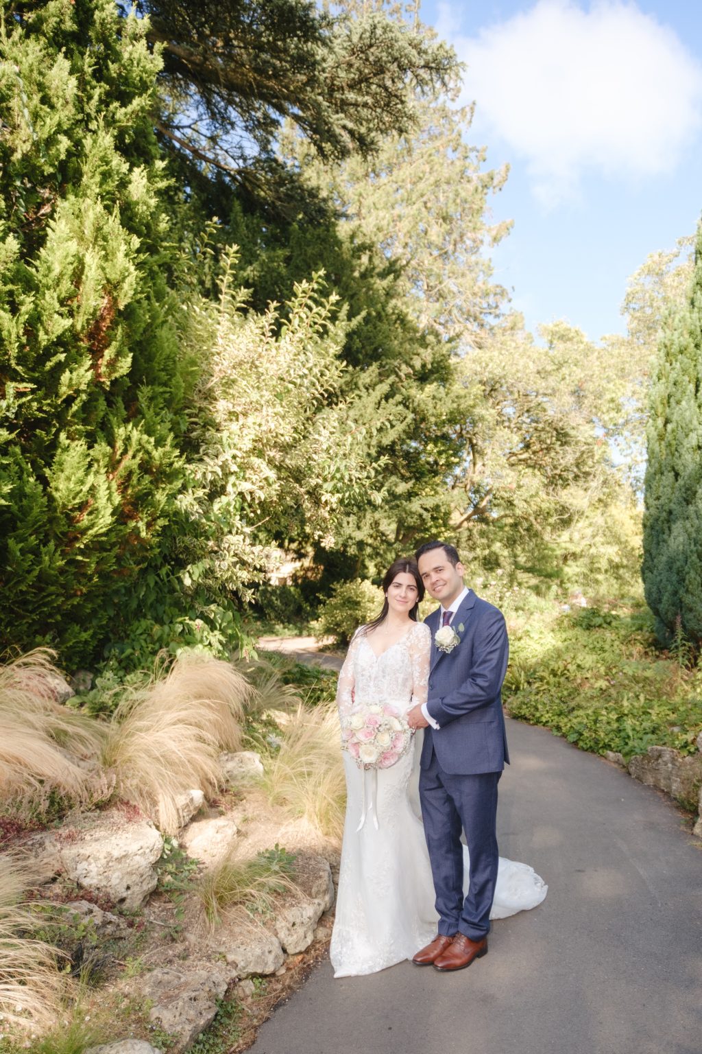 Habibi and Elaina on a garden path among trees and ornamental grasses beside the Temple of Minerva in Bath.