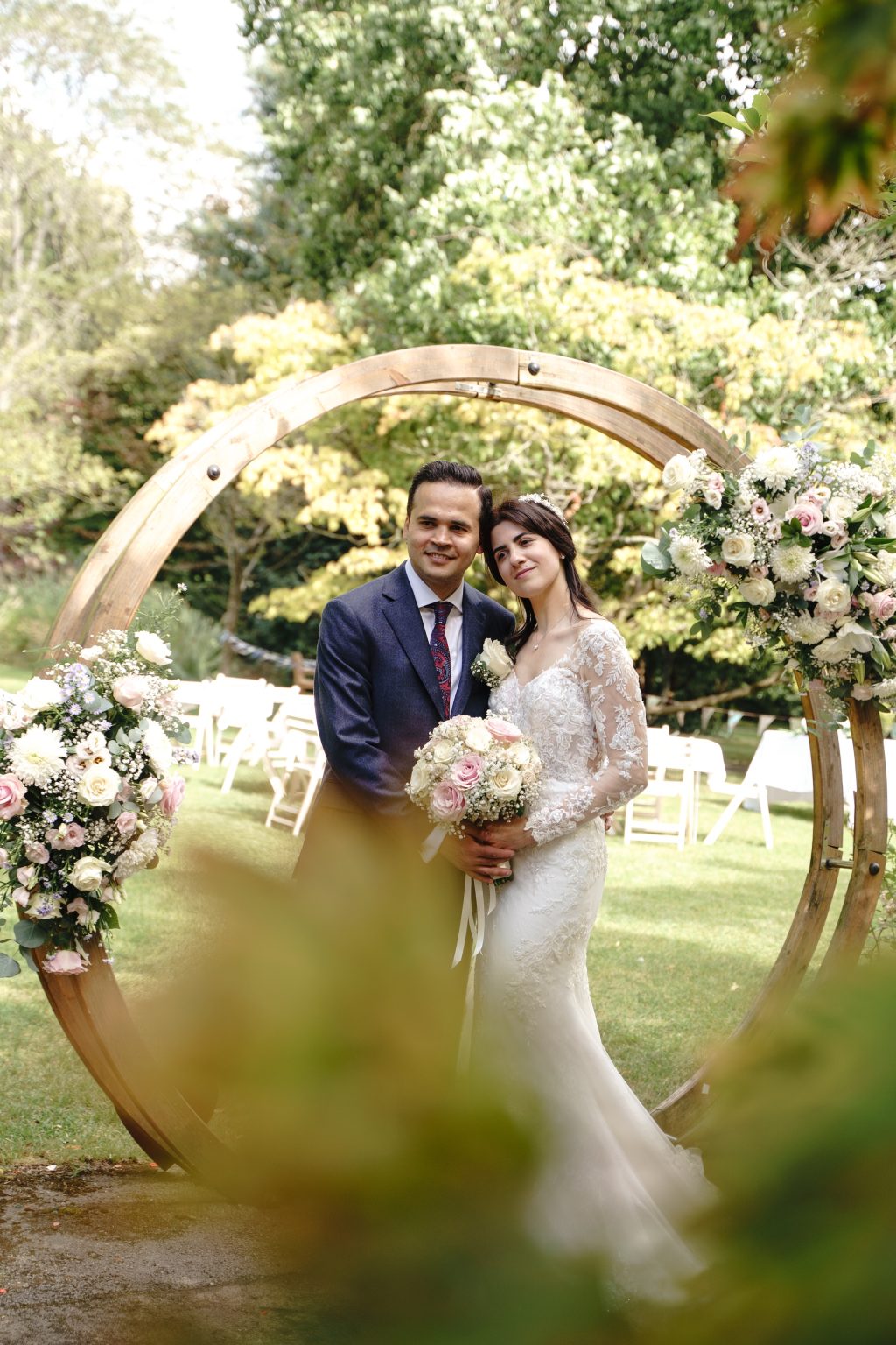 Habibi and Elaina beside a circular floral arch in Bath’s Botanical Gardens at their Temple of Minerva reception.