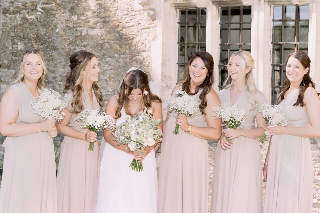 Alice and her bridesmaids with their bouquets beside Seymours Court’s stone wall.